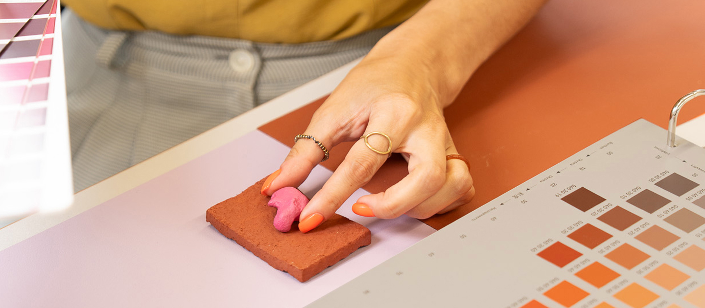 Hand wählt Farbmuster aus einer RAL Farbpalette aus.
Hand selecting colour samples from an RAL colour palette.