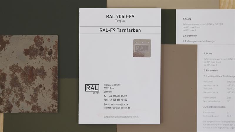 RAL F9 Farbregisterkarte. Das Bild zeigt das verbindliche Farbmuster zu den Bundeswehrtarnfarben. Exemplarisch liegt die Farbe "Tarngrau" mittig, zugefaltet. Im Hintergrund sind weitere Tarnfarben zu sehen. | RAL FARBEN

RAL F9 colour primary standard card. The picture shows the binding colour samples for the Bundeswehr camouflage colours. As an example, the colour “camouflage grey” is in the middle, folded. More camouflage colours can be seen in the background. | RAL COLOURS